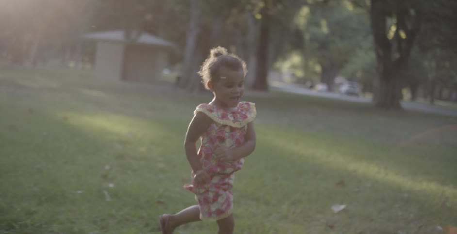 Little girl running through bubbles while playing at the park
