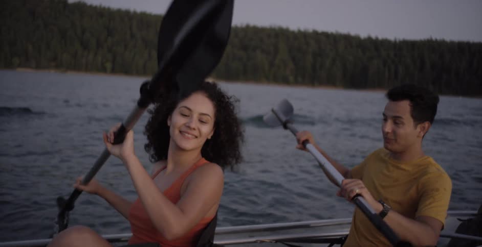 A couple riding a transparent kayak on a lake