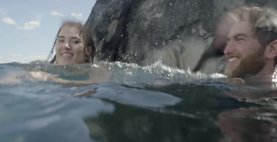 A man and woman swim in the water together