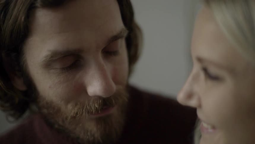 A man sitting next to and gazing at a smiling woman