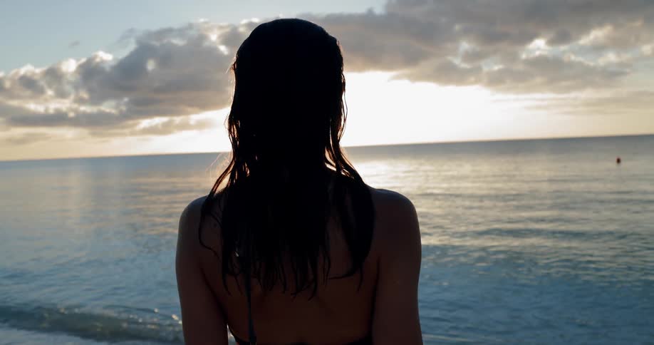 A white woman looks across the ocean