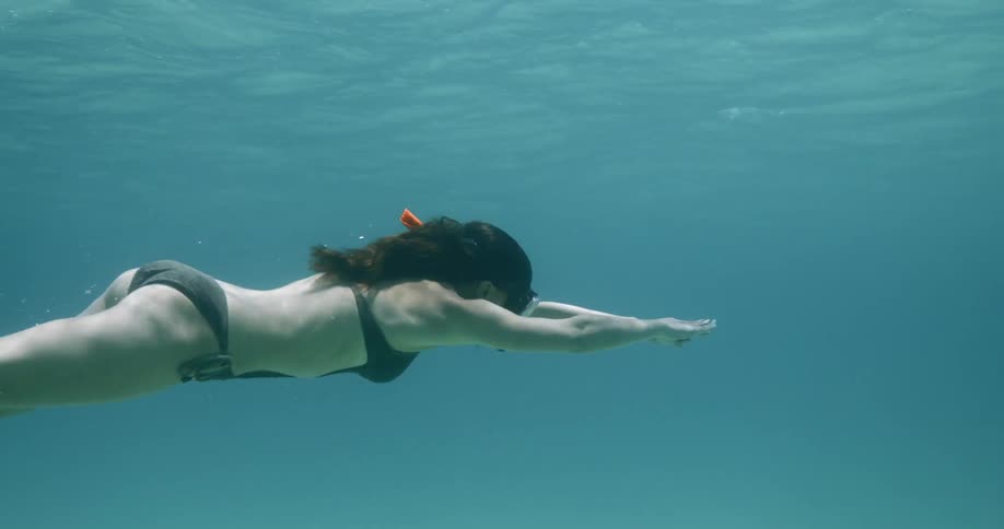 Woman rolls over as she swims underwater