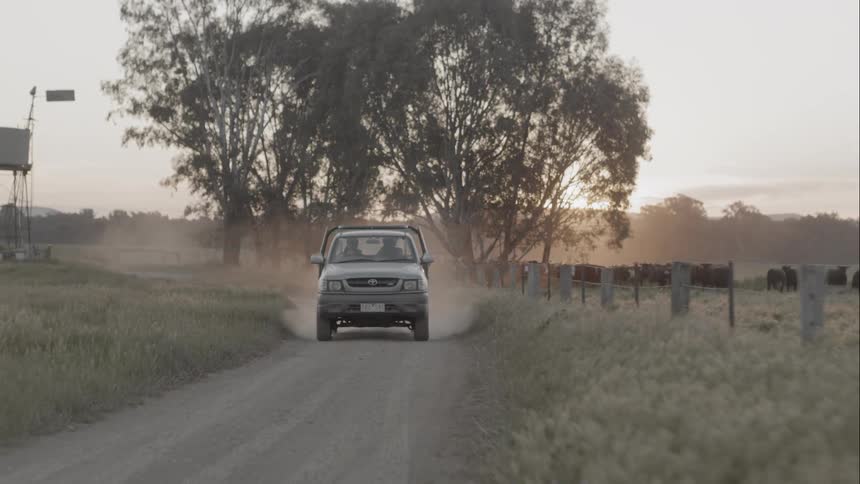 A pickup truck driving in a dirt road