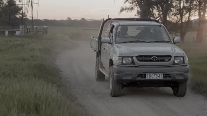 Pickup truck driving on a dirt road on rural area