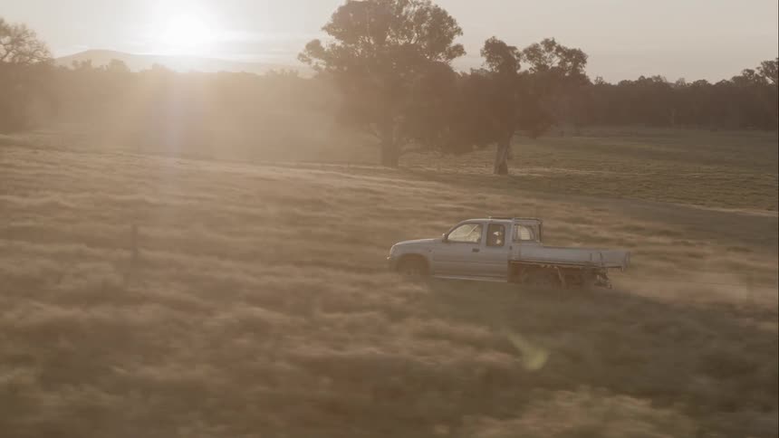 White pickup truck driving up a narrow road