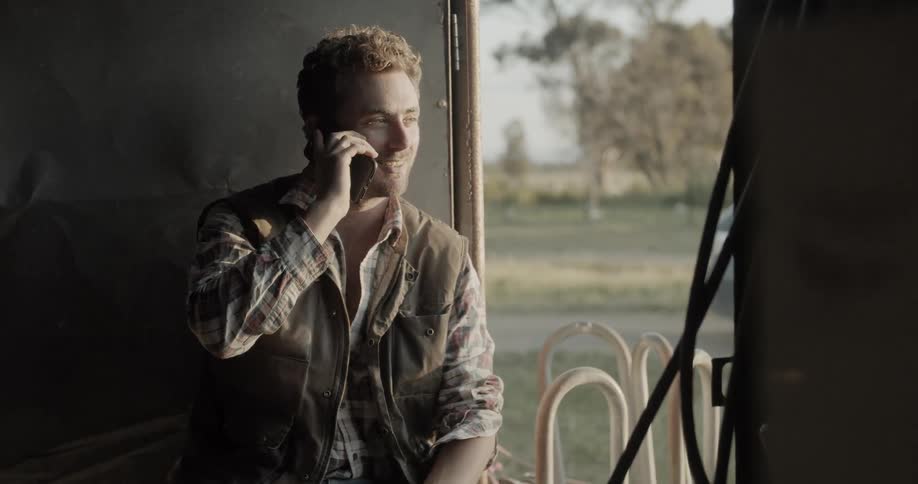 Man sits near window talking on mobile phone