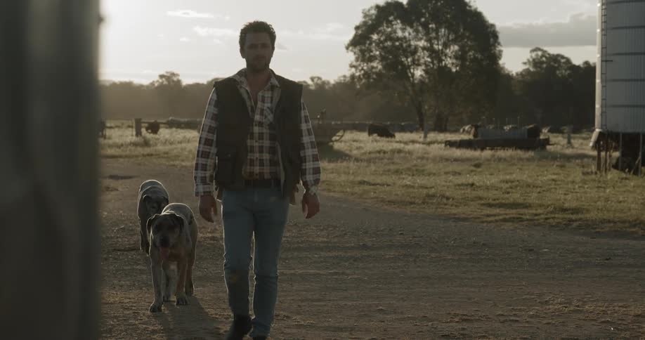 A man walking with a pair of doors in a rural area