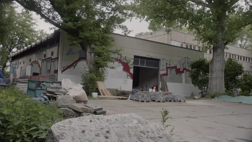 A glass garage door on a concrete block building being opened during the day