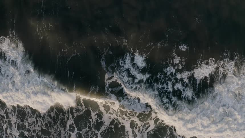 Waves crash against the shores to create a significant froth and rip tide