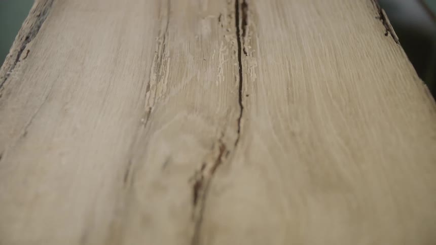 A milled plank of wood with cracks