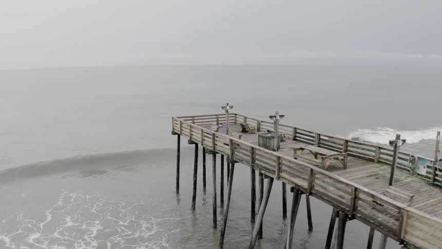 A wooden pier jutting out at the ocean