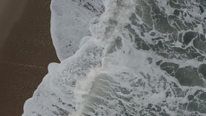Dark waves crash on a shoreline