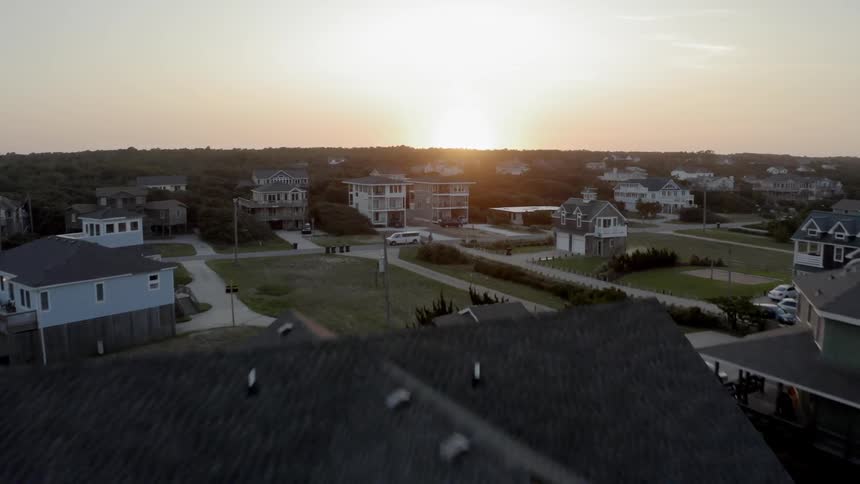 A coastal town of large multilevel houses along the sandy beach