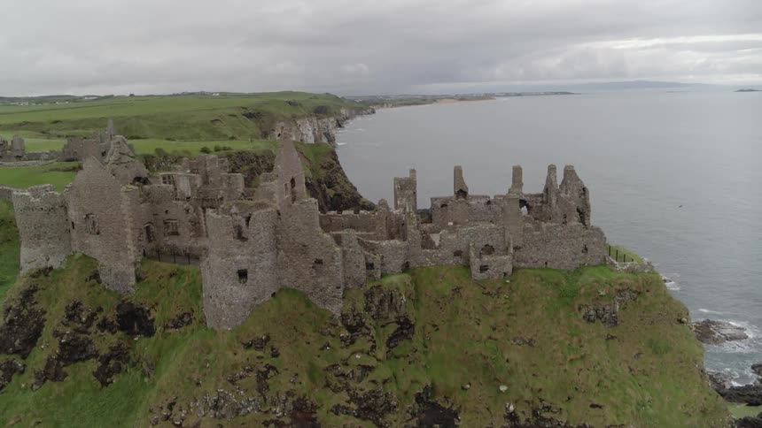 The ruins of dunluce castle on a cliff above the ocean
