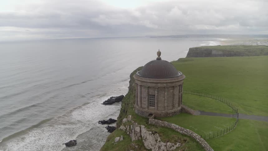 Flying over ruins that are on a cliff next to the ocean