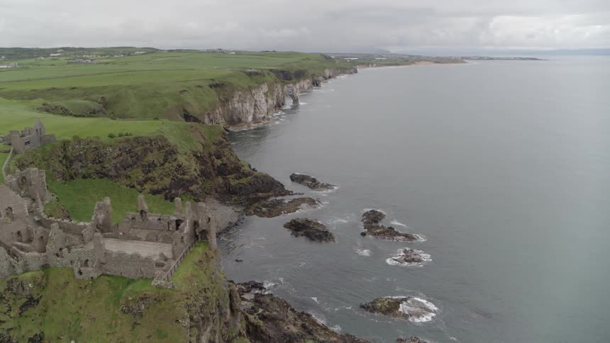 The ruins of a castle on a cliff above a coastline