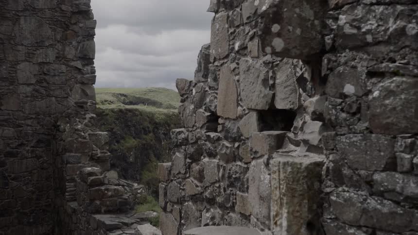 The partially standing stone walls of a large ancient monument on the coast