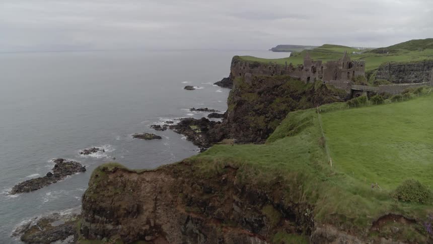 An old and crumbling stone building stands at the edge of steep rocky cliffs that give was to the vast ocean