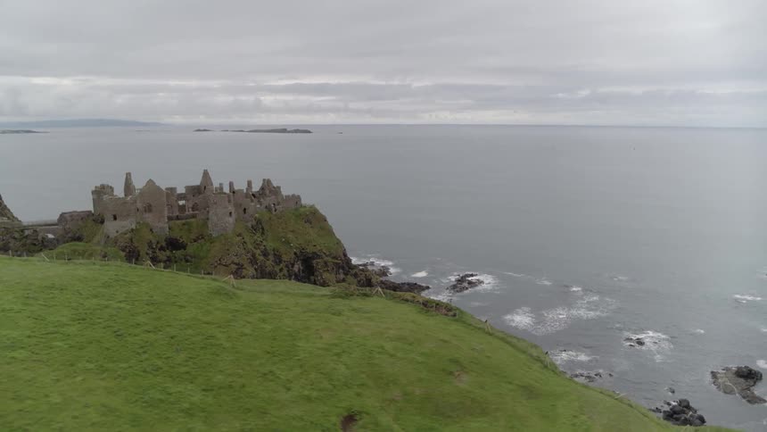 The ruins of a castle on a head above the sea on a cloudy day