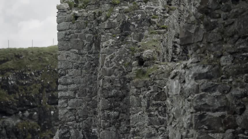 The partially standing stone walls of a large ancient monument on the coast