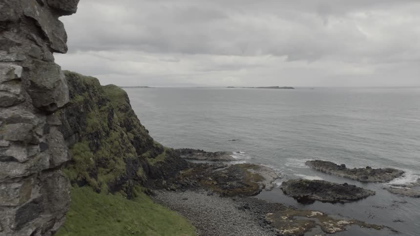 The walls of an ancient monument at a rocky cliff face by the sea