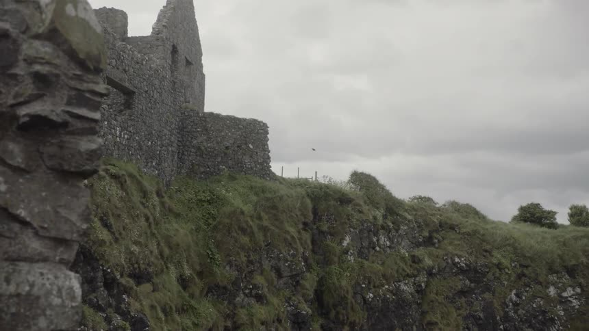 The partially standing walls of dunluce castle on a cloudy day