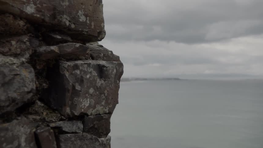 A rocky cliff with the ocean in the background