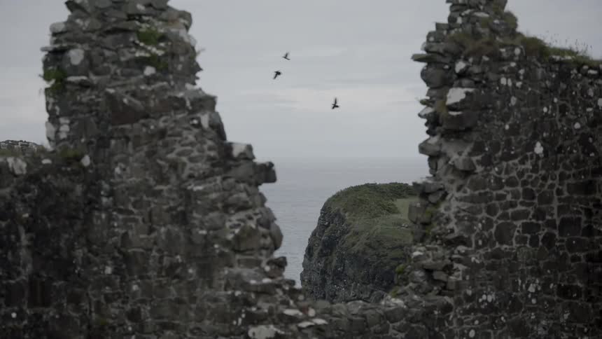 The partially standing walls of a large ancient monument on the coast