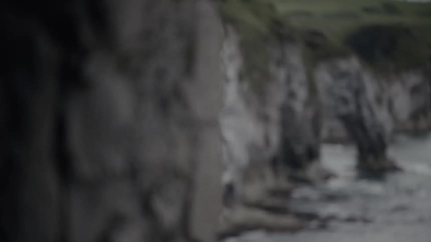 A rocky coastal cliff side along the ocean