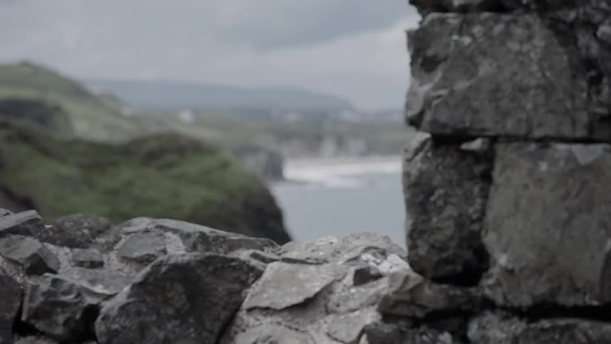 A rocky wall with the ocean in the background