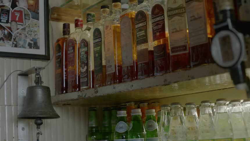 Bottles of alcohol sitting on shelves