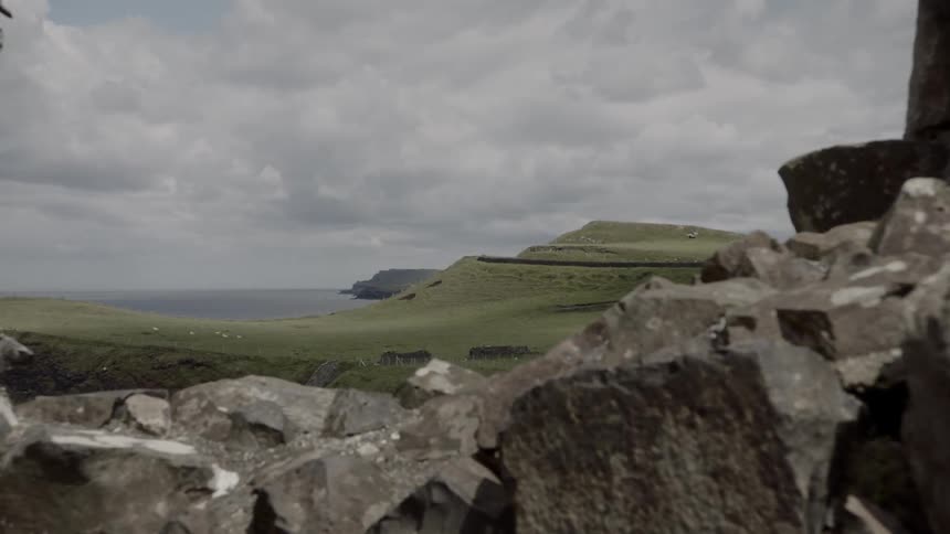 A road leading through a field and boulders to get to the coast