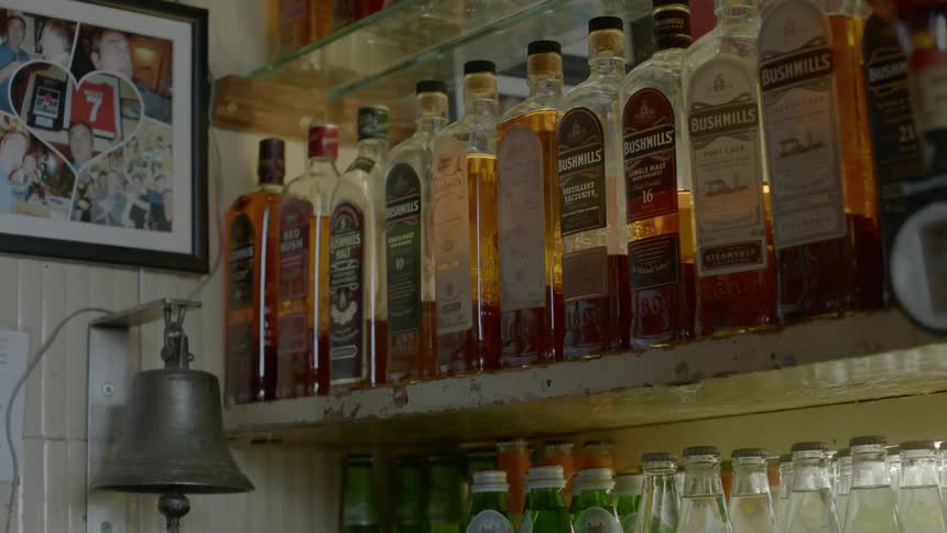 Bottles of liquor displayed on a bar shelf
