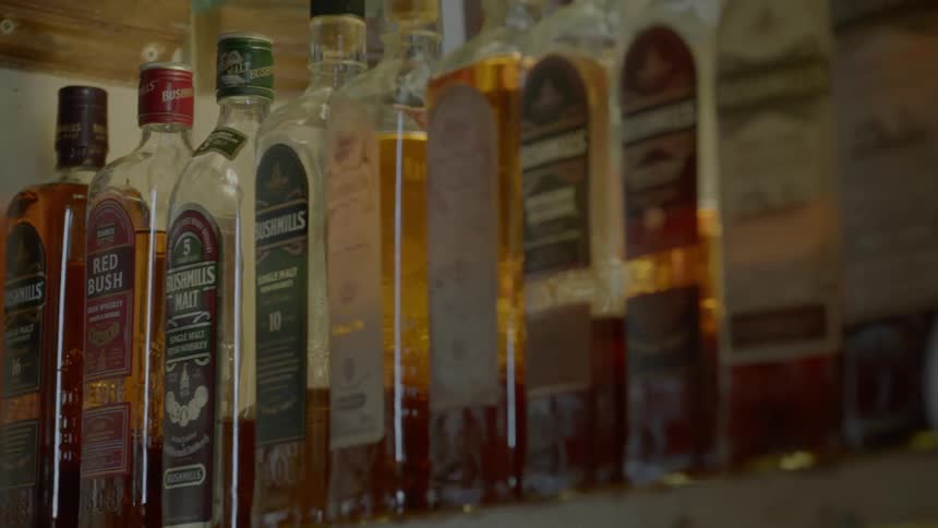 Bottles of alcohol sitting on a shelf
