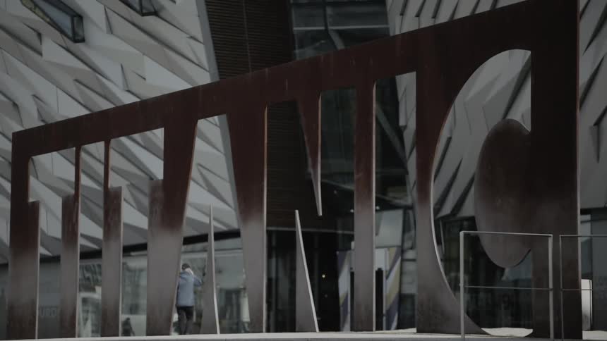 People walk towards the entrance of the titanic belfast building