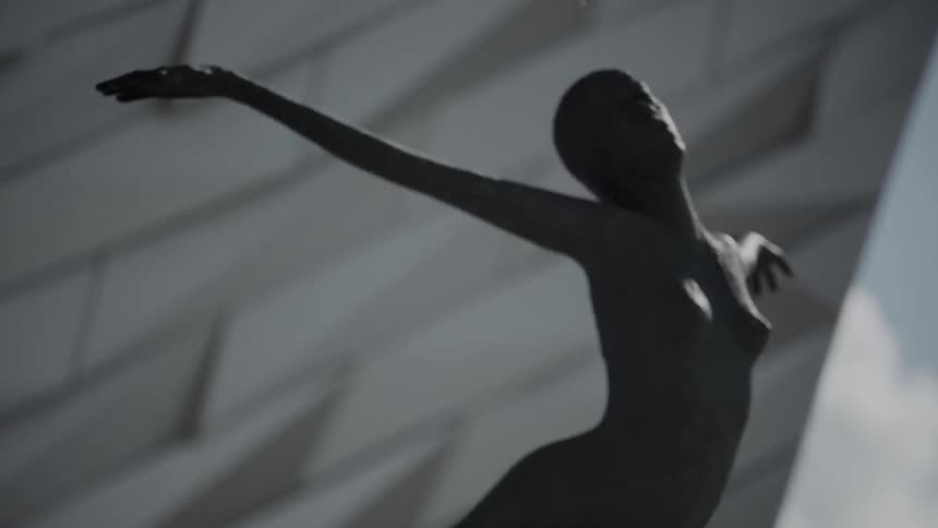 A small statue of a nude female with outstretched arms