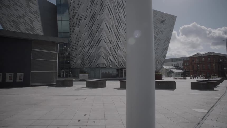 A modern building with a distinctive textured cladding and titled entrance in daylight