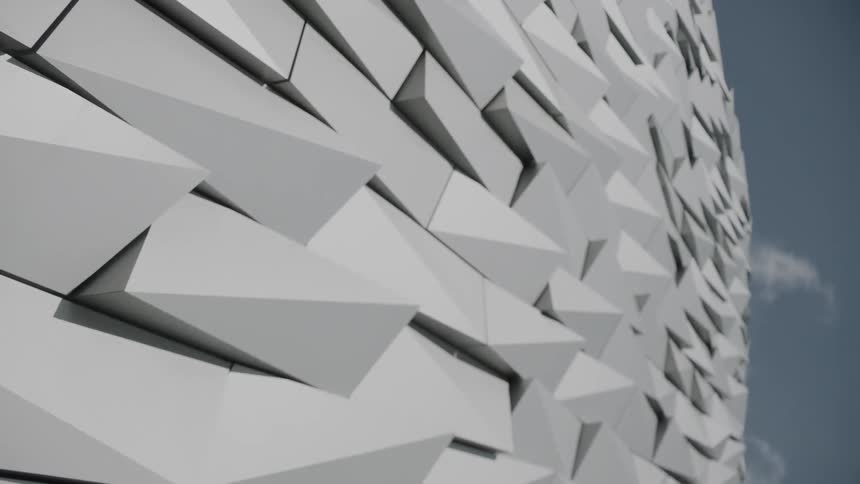 The uneven and overlapping siding of an ornate building facade on a sunny day