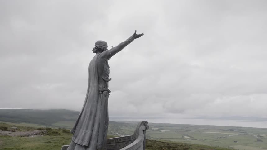 Statue of a man on a boat with hands stretched up
