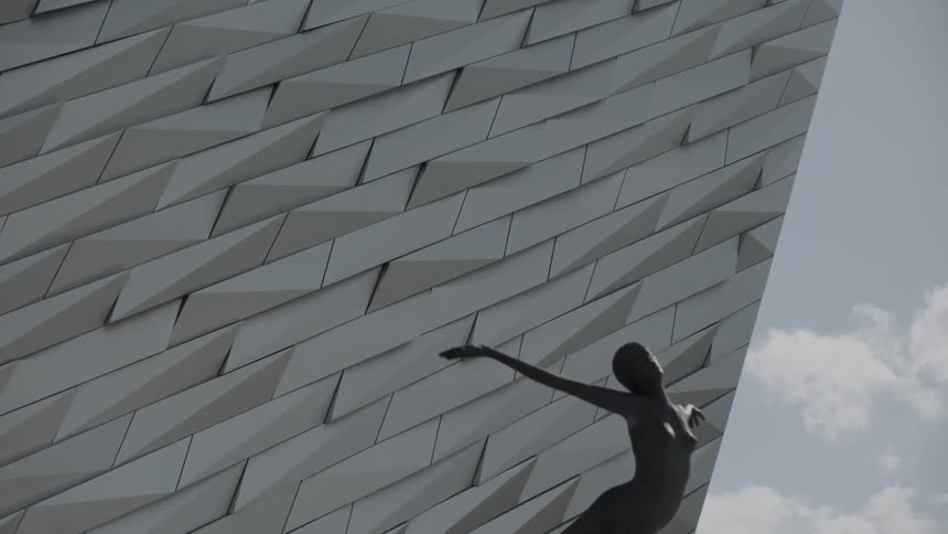 A closeup of a side of a building by a statue
