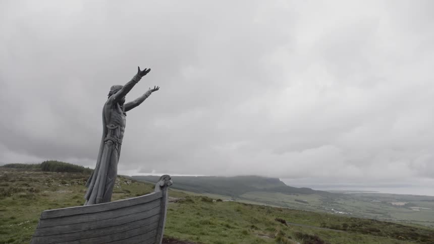 A statue of a person standing on a boat with their hands up