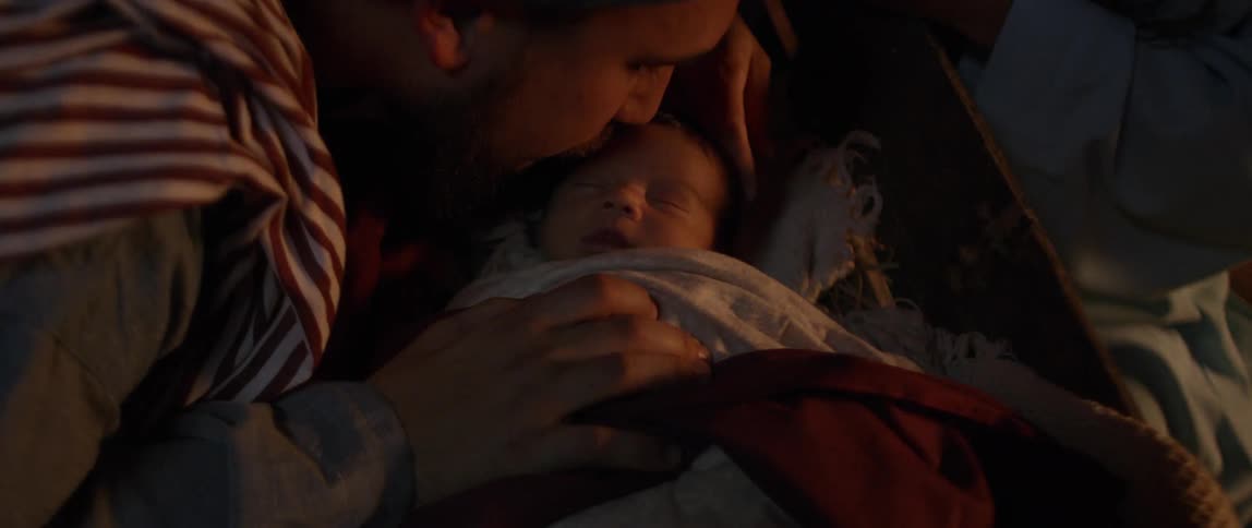 Man and woman touch infant