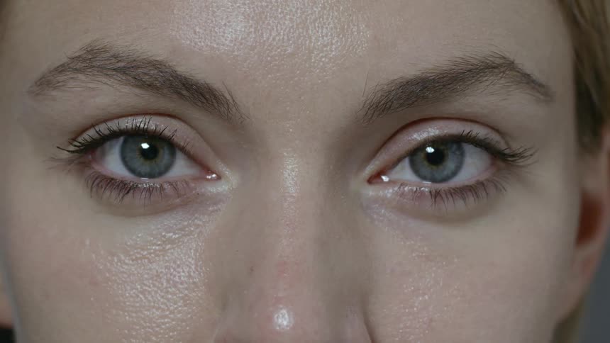 A woman blinks her eyes hard trying to wink