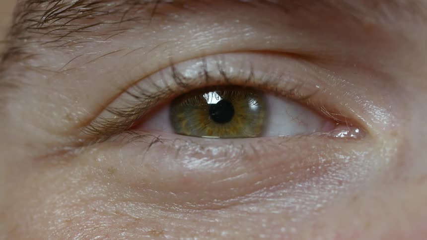 A man is looking around with only one eye showing
