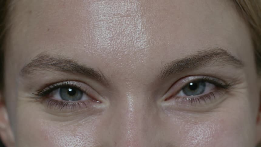 A woman smiling staring and blinking