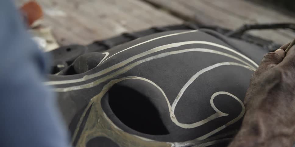 Man paints a tribal mask