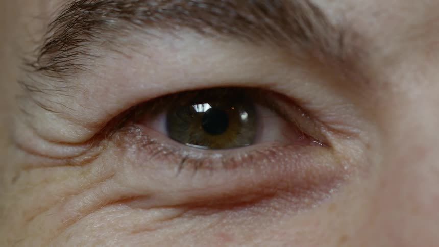 An extreme close up of a mans hazel eye