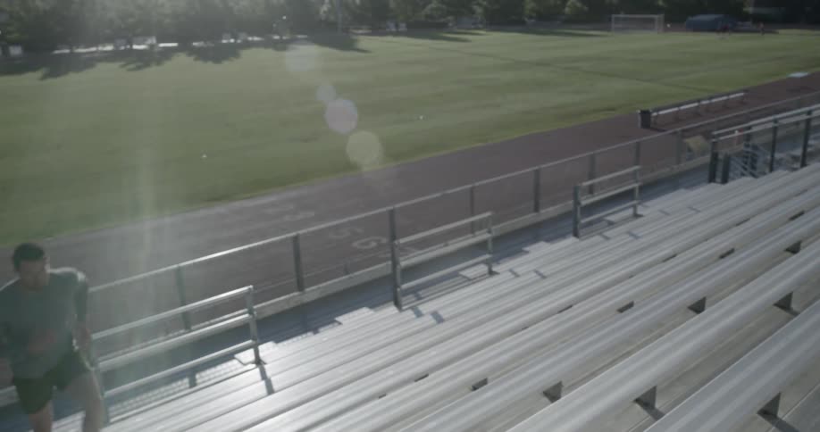 A man is running up bleacher seats