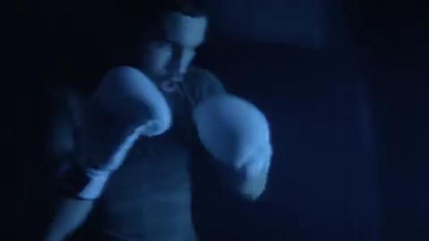 Strobe lights flashing while a man punches a punching bag