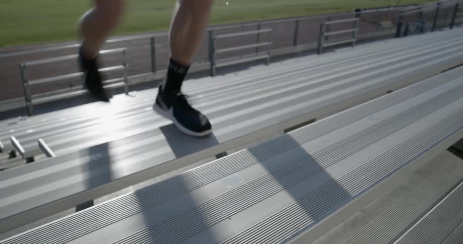 Man runs up bleachers and sports field